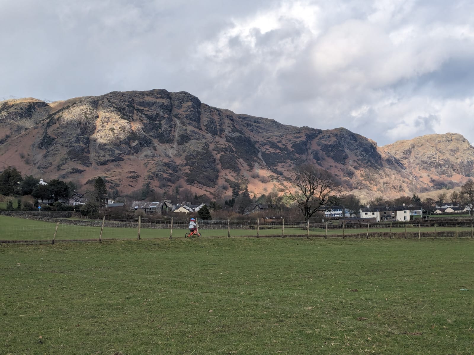 boy riding a bike with mountains behind him